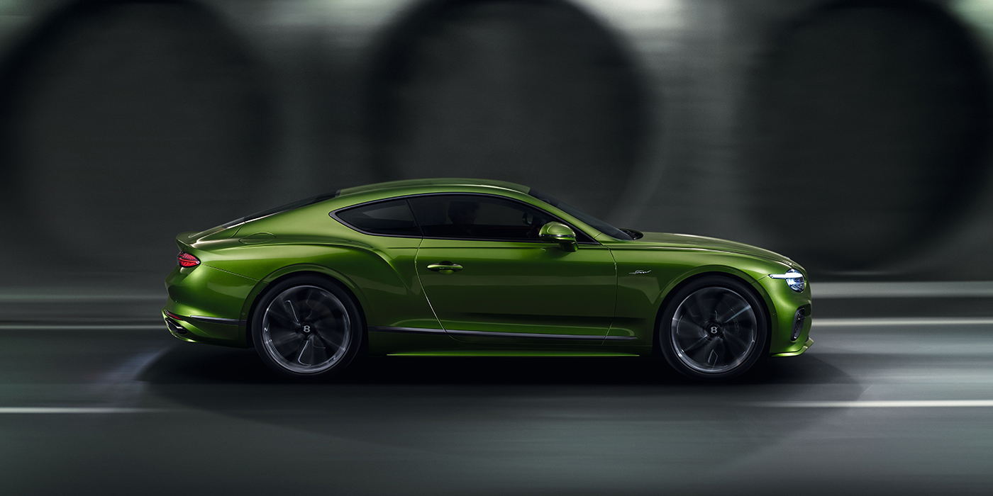 Bentley Oslo Bentley Continental GT coupe in Tourmaline Green paint driving in profile on a dark road
